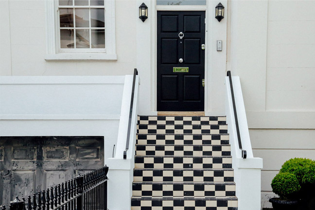 Black front door above chequered steps